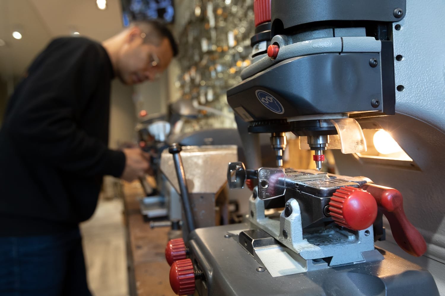 Reportage photo corporate dans l’atelier Alcof Sécurité, machine de reproduction de clés et savoir-faire métier.
