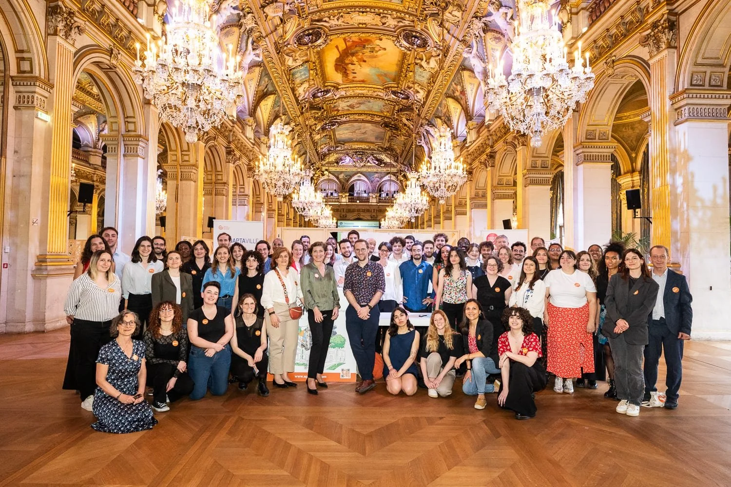 Photo de groupe des organisateurs et partenaires d'un salon professionnel à l'Hôtel de Ville de Paris.