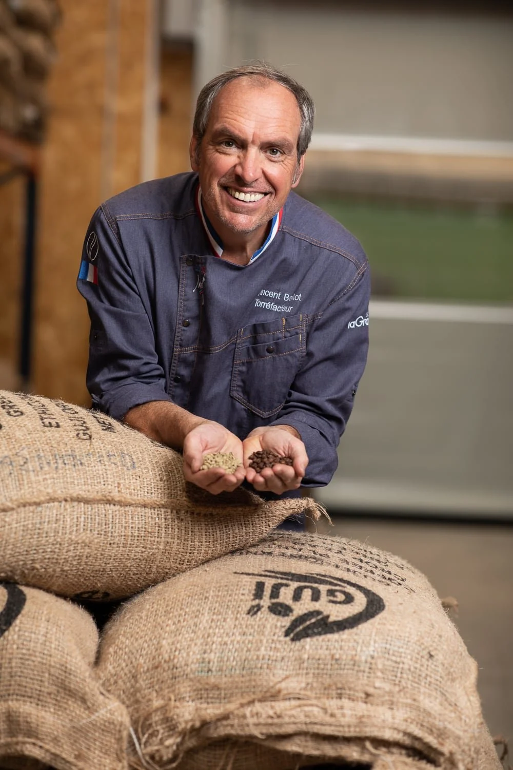 Portrait de Vincent Ballot présentant des grains de café vert et café torréfié chez Café Lagrange