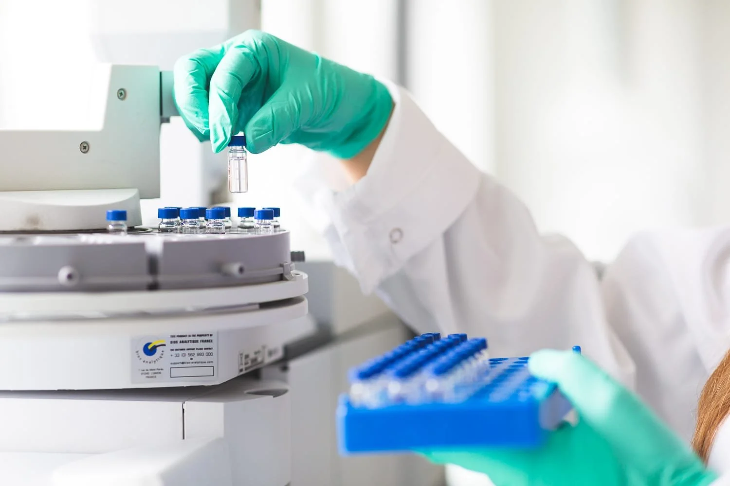 Pose d'un échantillon dans une machine d'analyse dans un laboratoire de recherche industriel