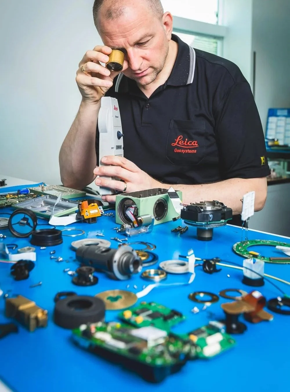 Photographe industriel – technicien contrôlant un instrument de mesure Leica en atelier