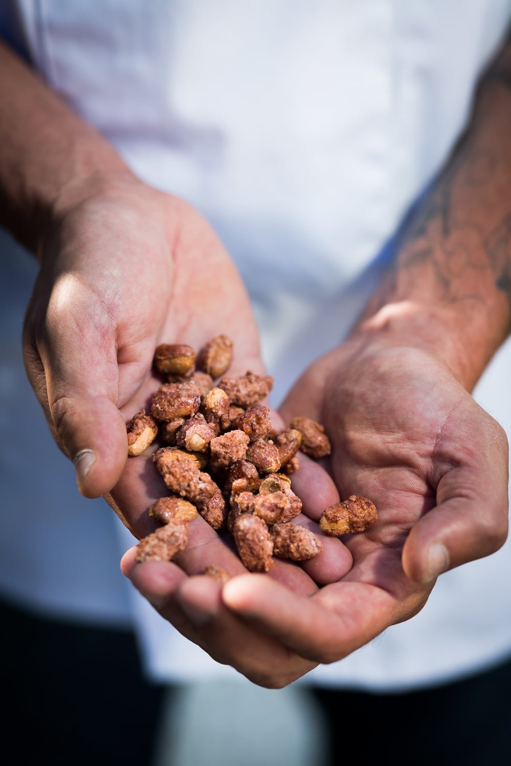 gros plan sur les mains de l'artisan tenant des pralines cuites
