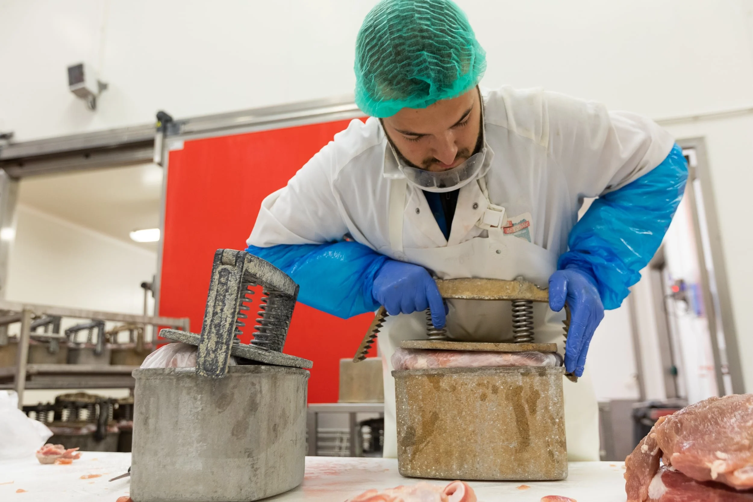 Opération de pressage du jambon chez Tradition de Vendée.