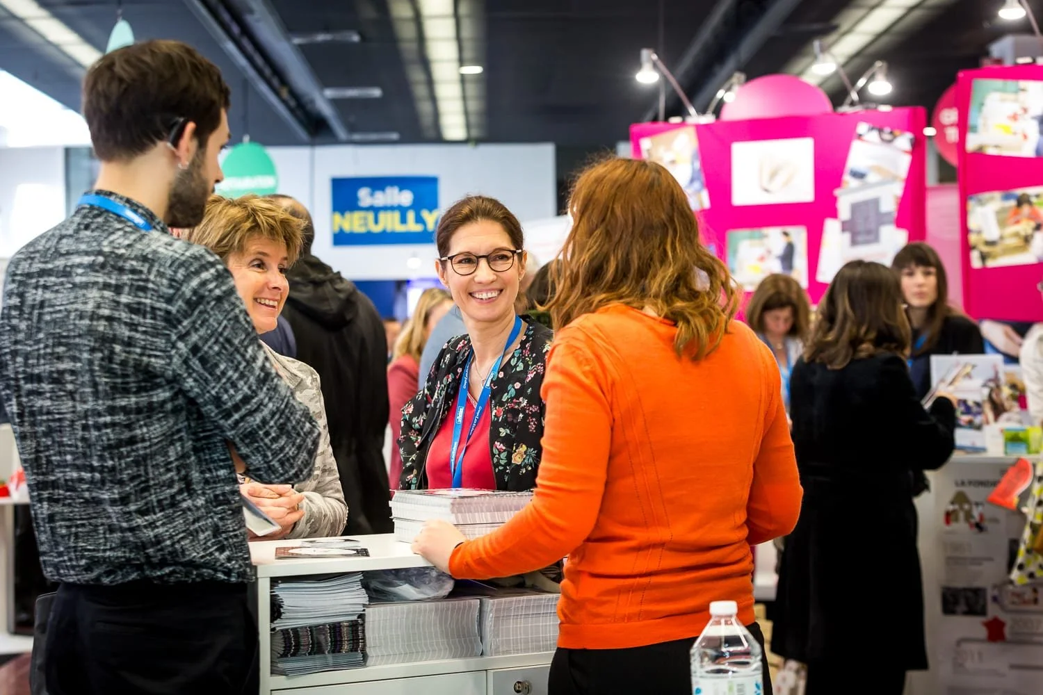 Reportage photo événementiel sur un salon professionnel à Paris avec échanges entre exposants et visiteurs sur un stand