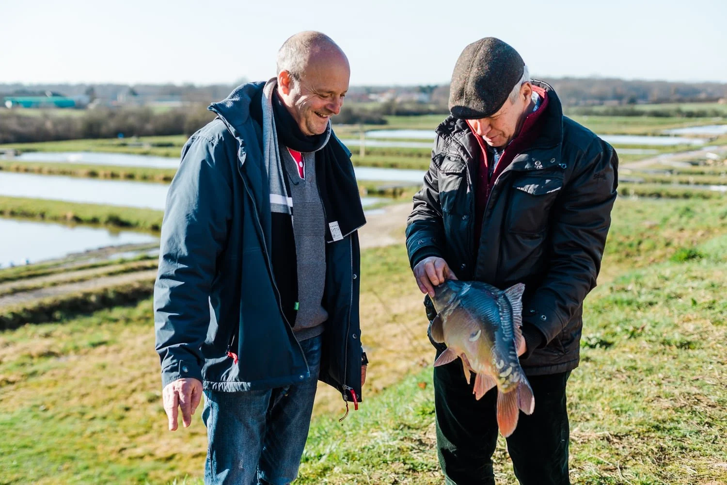 Photographe agriculture - échanges autour d'un poisson pêché dans un étang de la Dombes