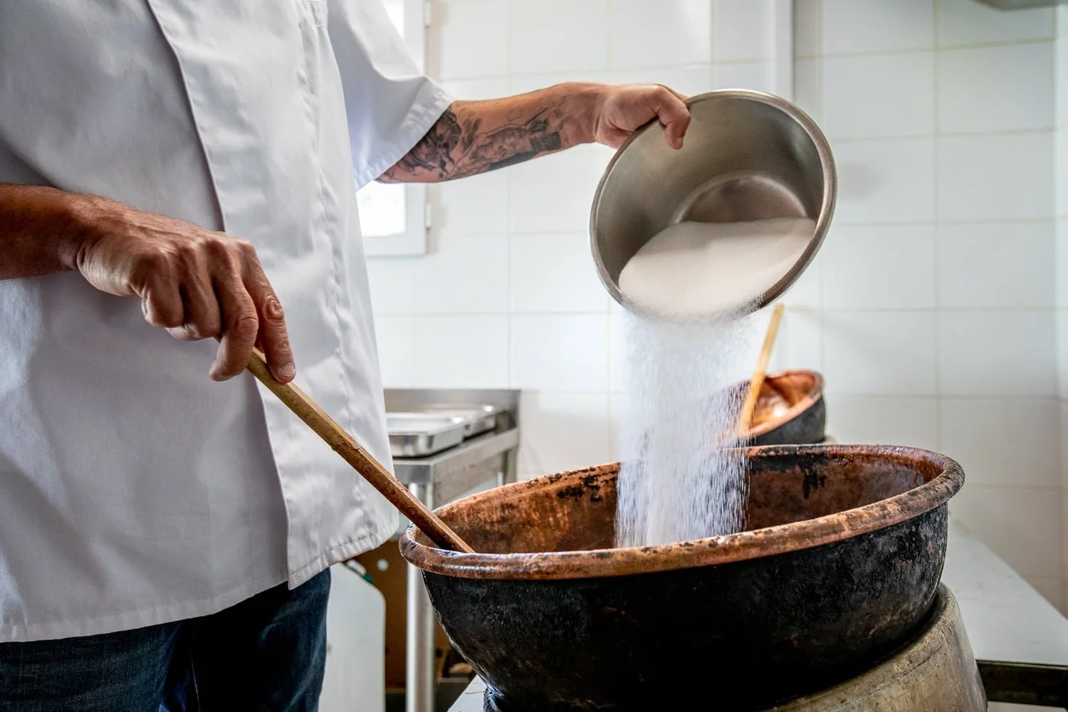 ajout de sucre dans la marmite pour la cuisson des pralines