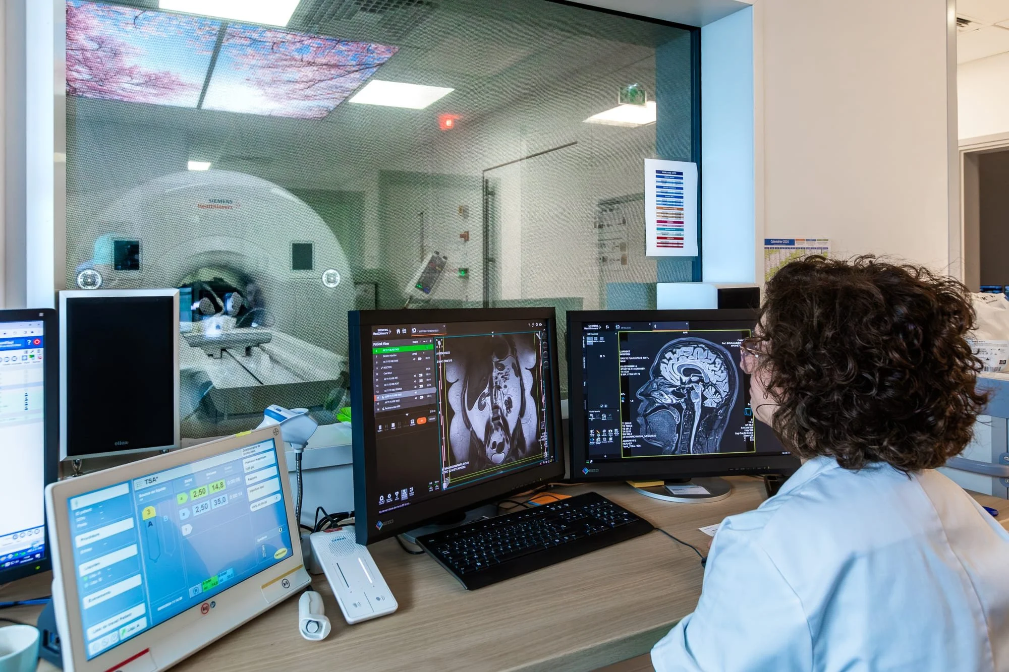 Photographe médical,  salle de contrôle IRM avec écrans d’imagerie médicale et équipe soignante.