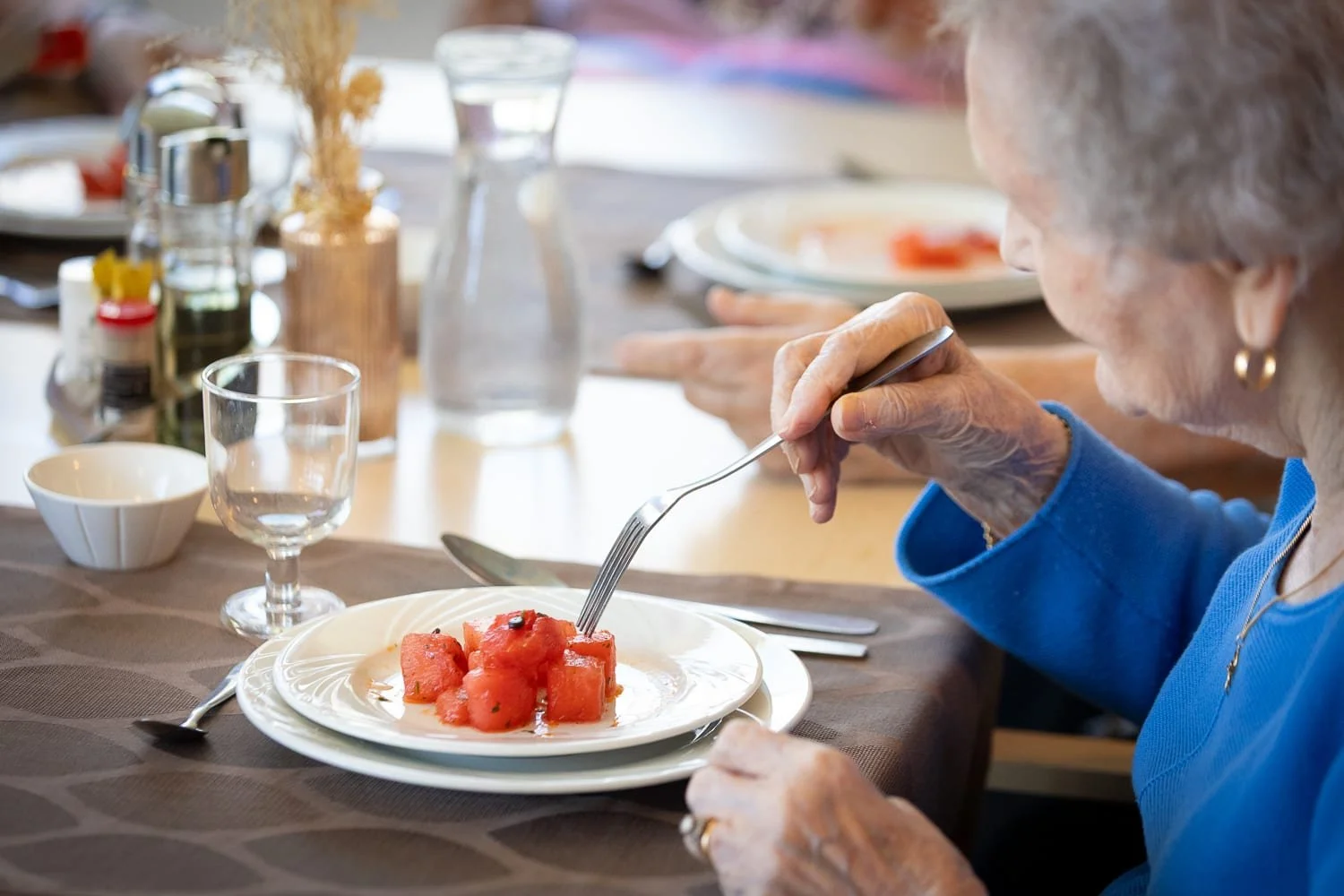 residente d'un ehpad degustant son dessert pendant le repas restauration collective