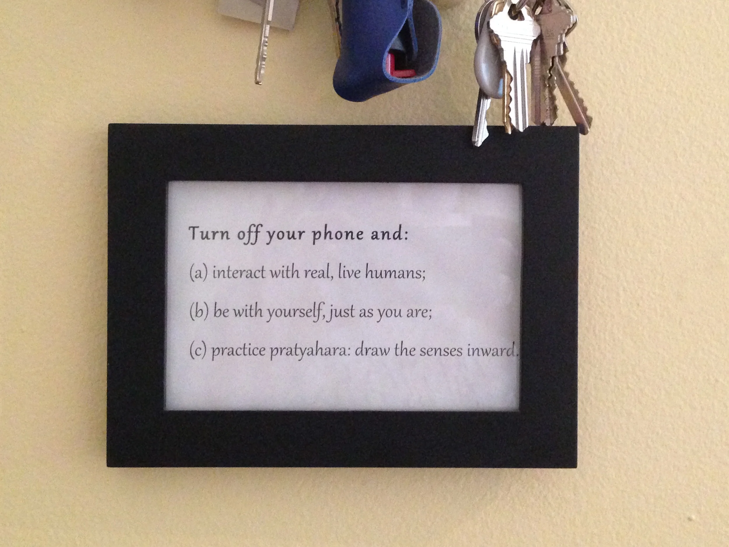 The sign I keep by my keys to help me remember to make my home a sanctuary. Right above you'll see my pepper spray. Because a city yogini's sometimes gotta practice pratyahara and sometimes gotta lay down some smack.