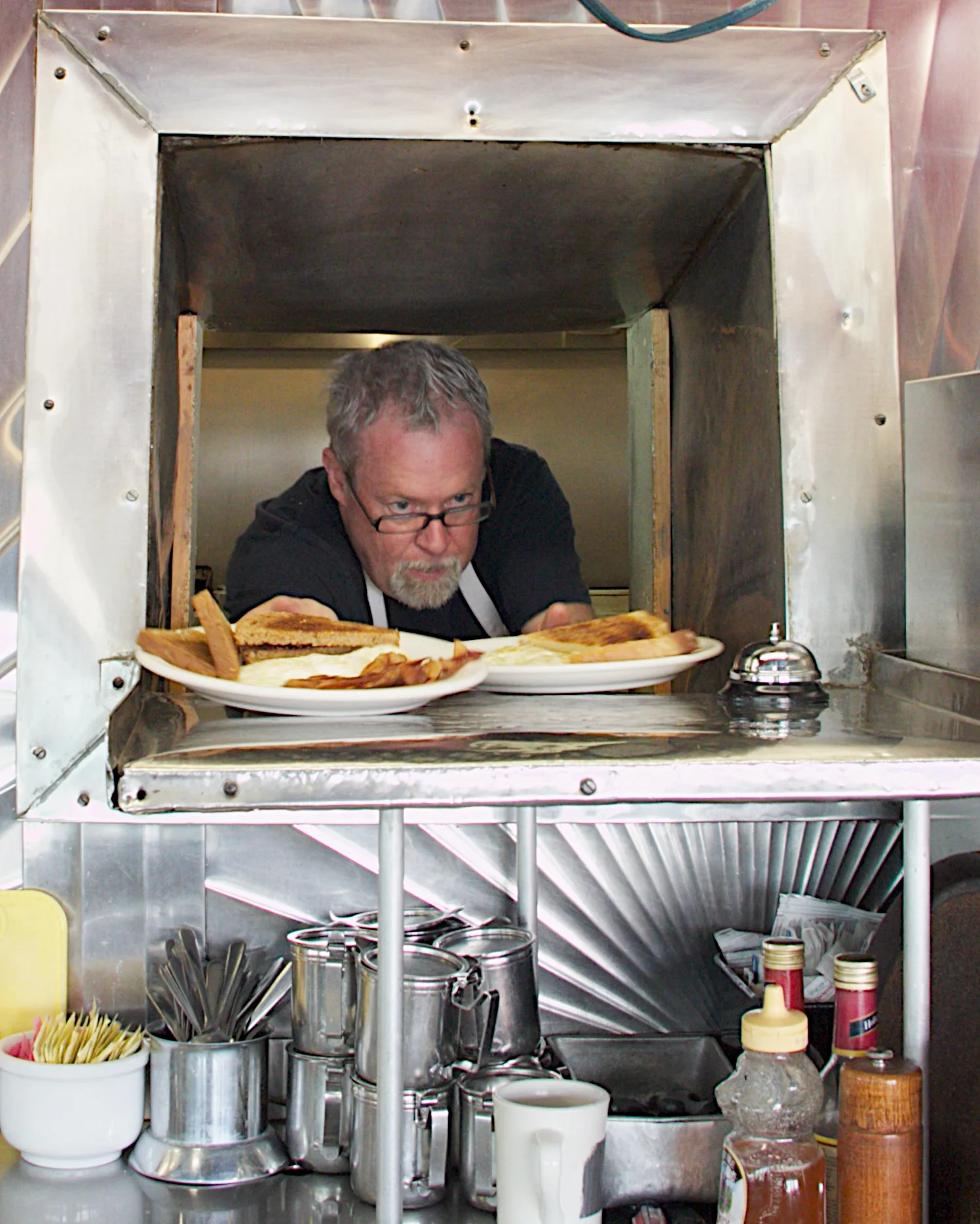 Mike Giberson, the most active owner, is in the kitchen by 5am. He starts with dozens of biscuit. For the breakfast rush, he's pushing food out to the counter.