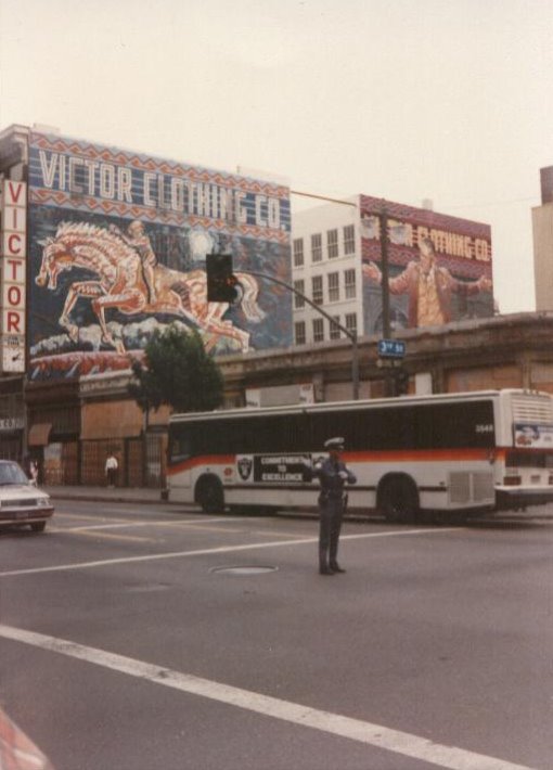 LA in 1990. This is downtown, about twenty minutes from Compton. This was the first and last tiem I saw a cop directing traffic in LA. I mean, what's going on here, there are functioning traffic lights behind him. Interesting note, you can see the LA Raiders banner on the bus, the team had just defected from Oakland. They went back of course, and since then LA has not had an NFL team.