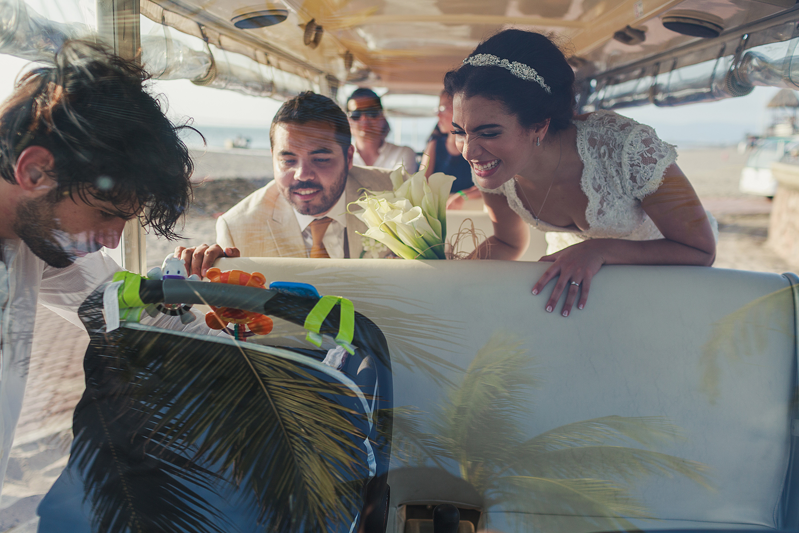 Novio y novia admirando el bebé de un invitado a bordo de un carrito de transporte en el hotel Grand Mayan en Nuevo Vallarta