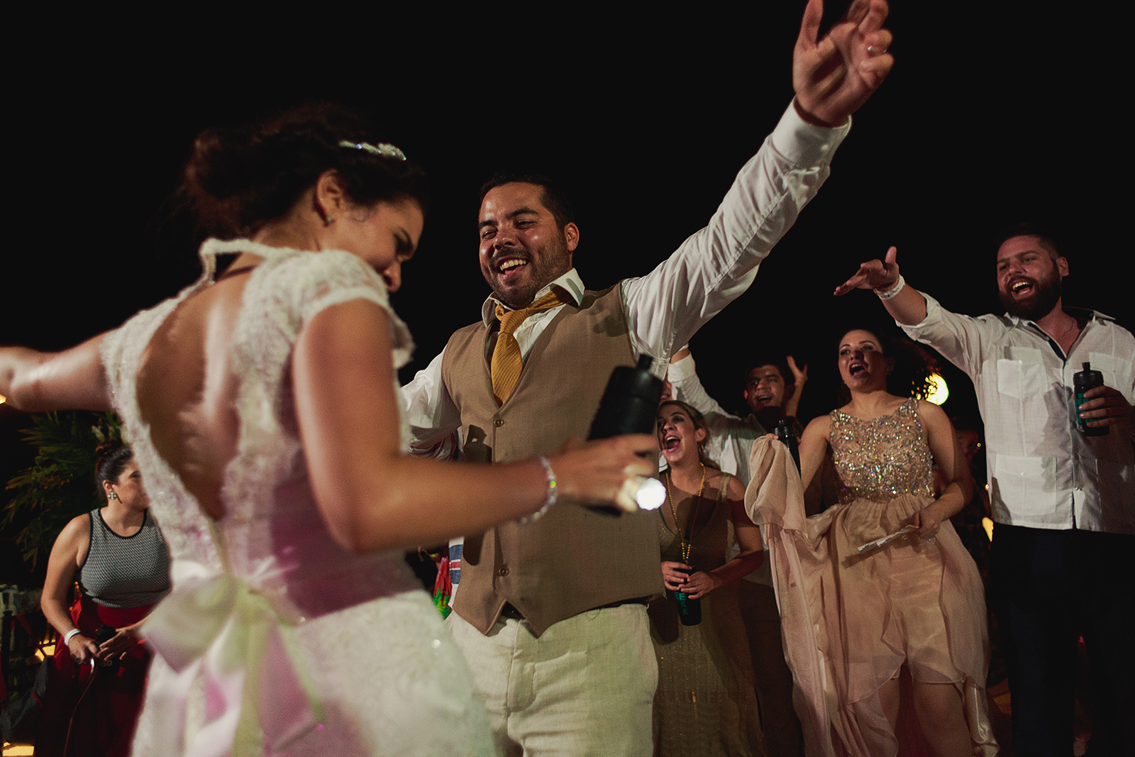 Novio y novia bailando en la pista mientras invitados los animan durante la recepción de su boda en Grand Mayan Nuevo Vallarta