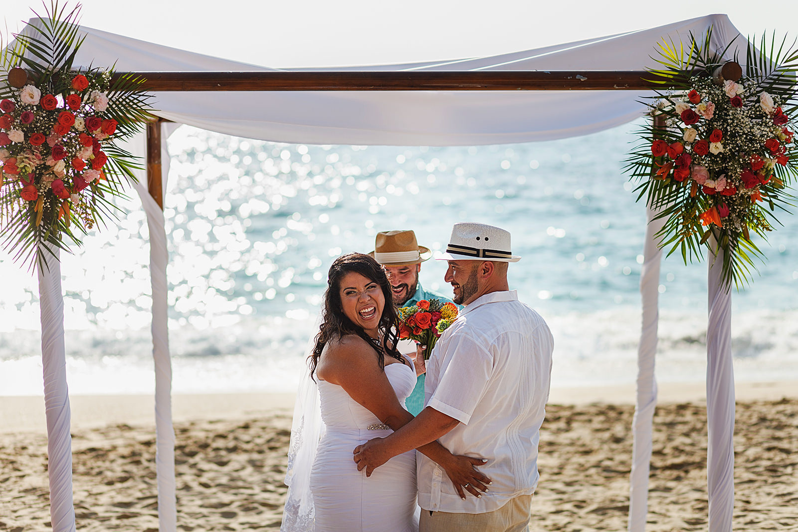 Bride turns at guests during her beach wedding ceremony