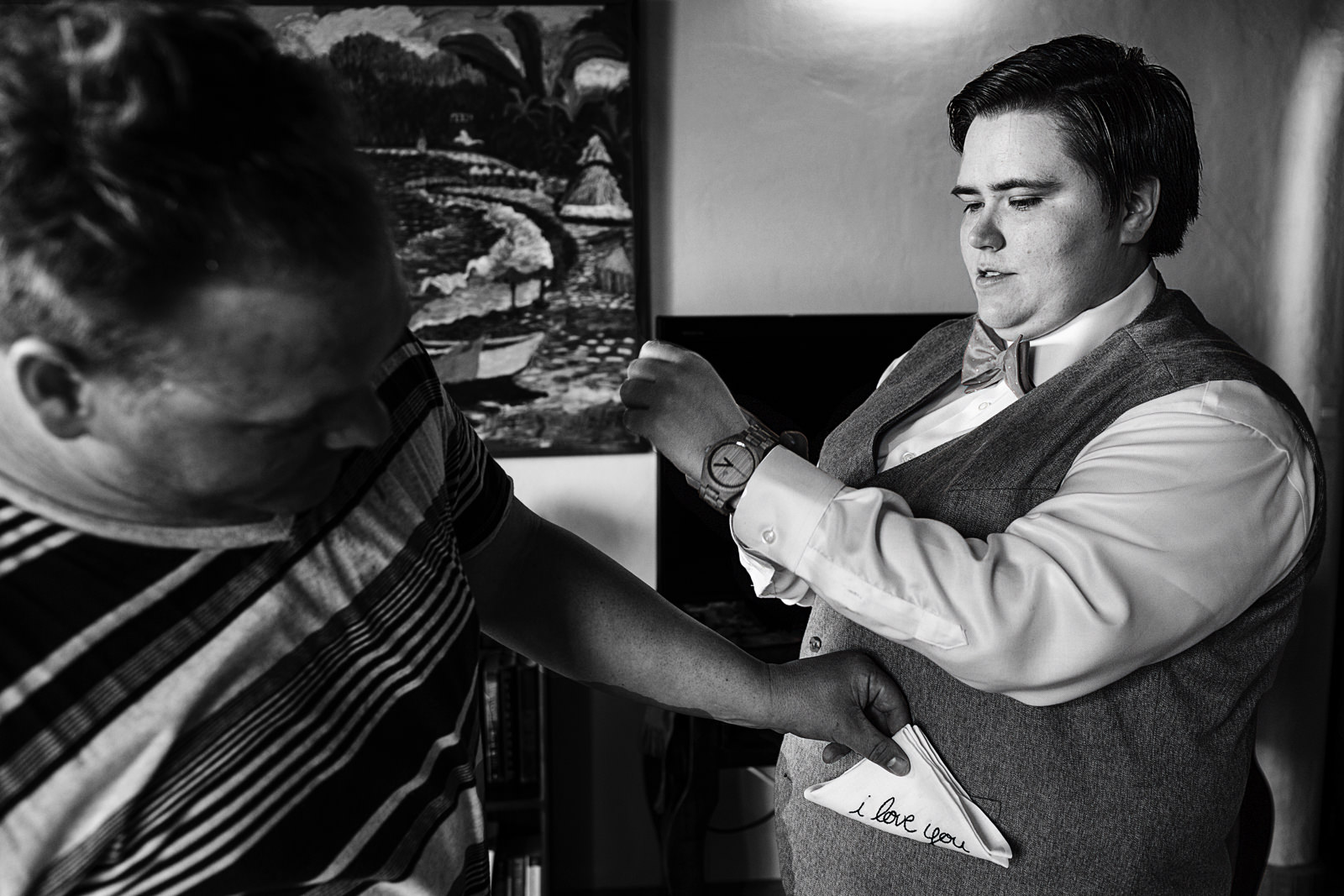 bride putting watch on while guest fixes handkerchief