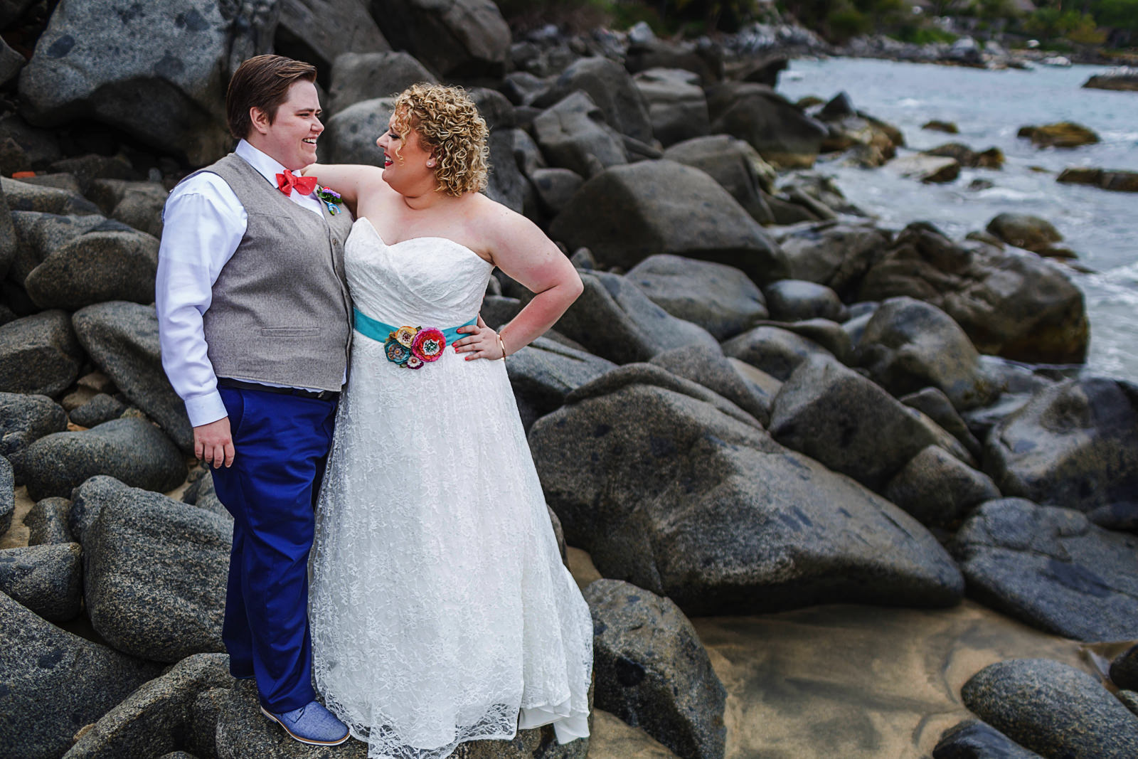 LGBTQ Brides standing on rock by the ocean