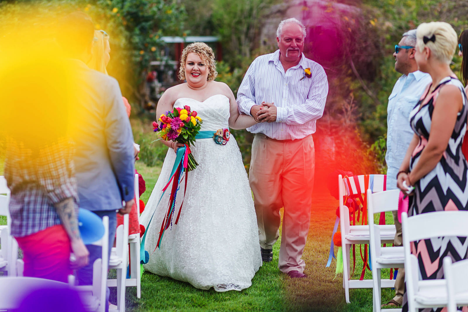 Bride and dad walking down the aisle on green grass
