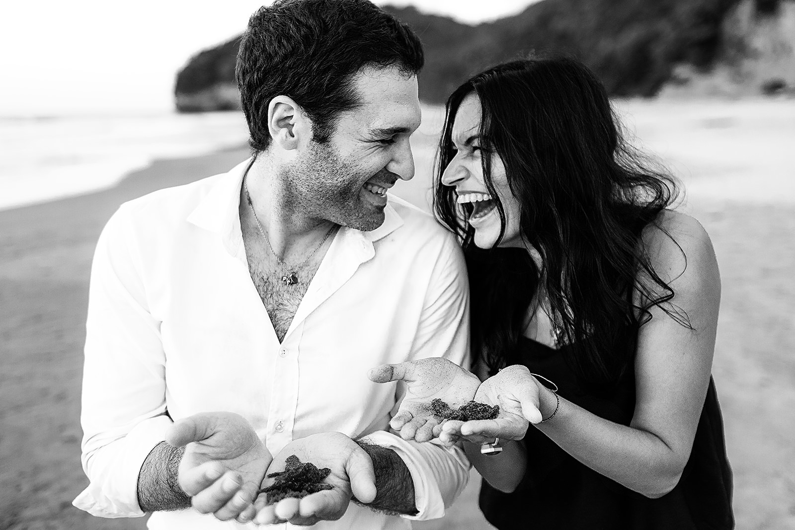 Couple laughing and holding baby turtles for release at Imanta Resort - Punta de Mita, Mexico