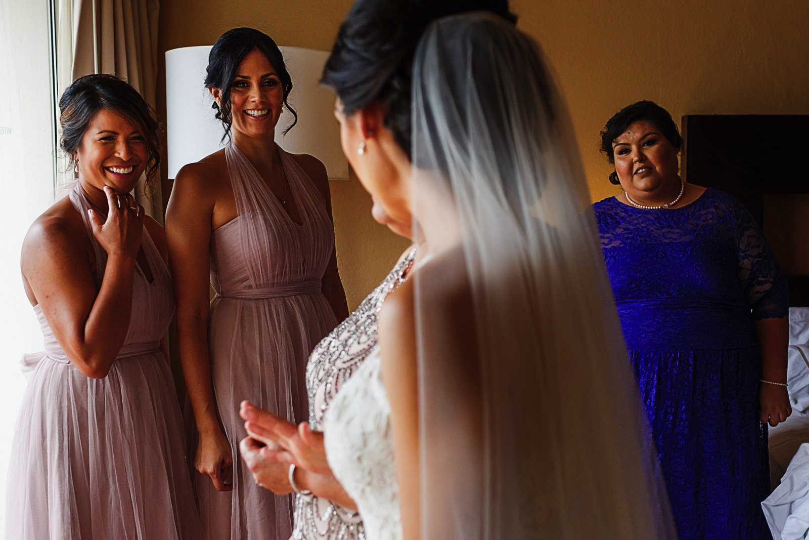 Bridesmaids and maid of honor react at bride all ready to go
