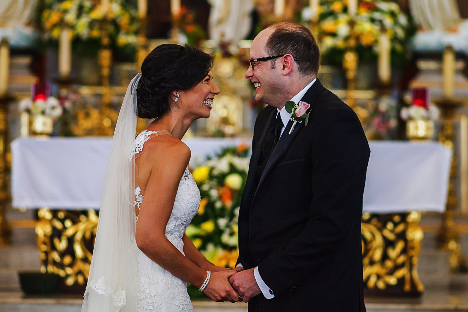Groom and bride laugh after kiss at Lady of Guadalupe church, downtown Puerto Vallarta, Mexico