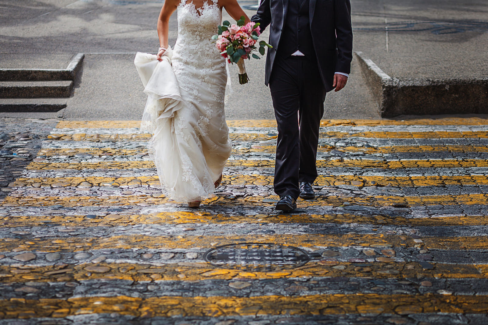 Groom and bride walking on yellow stripes downtown Puerto Vallarta, Mexico