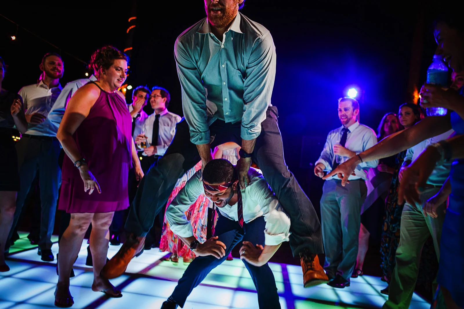 Guest jumping over other guest at wedding reception party