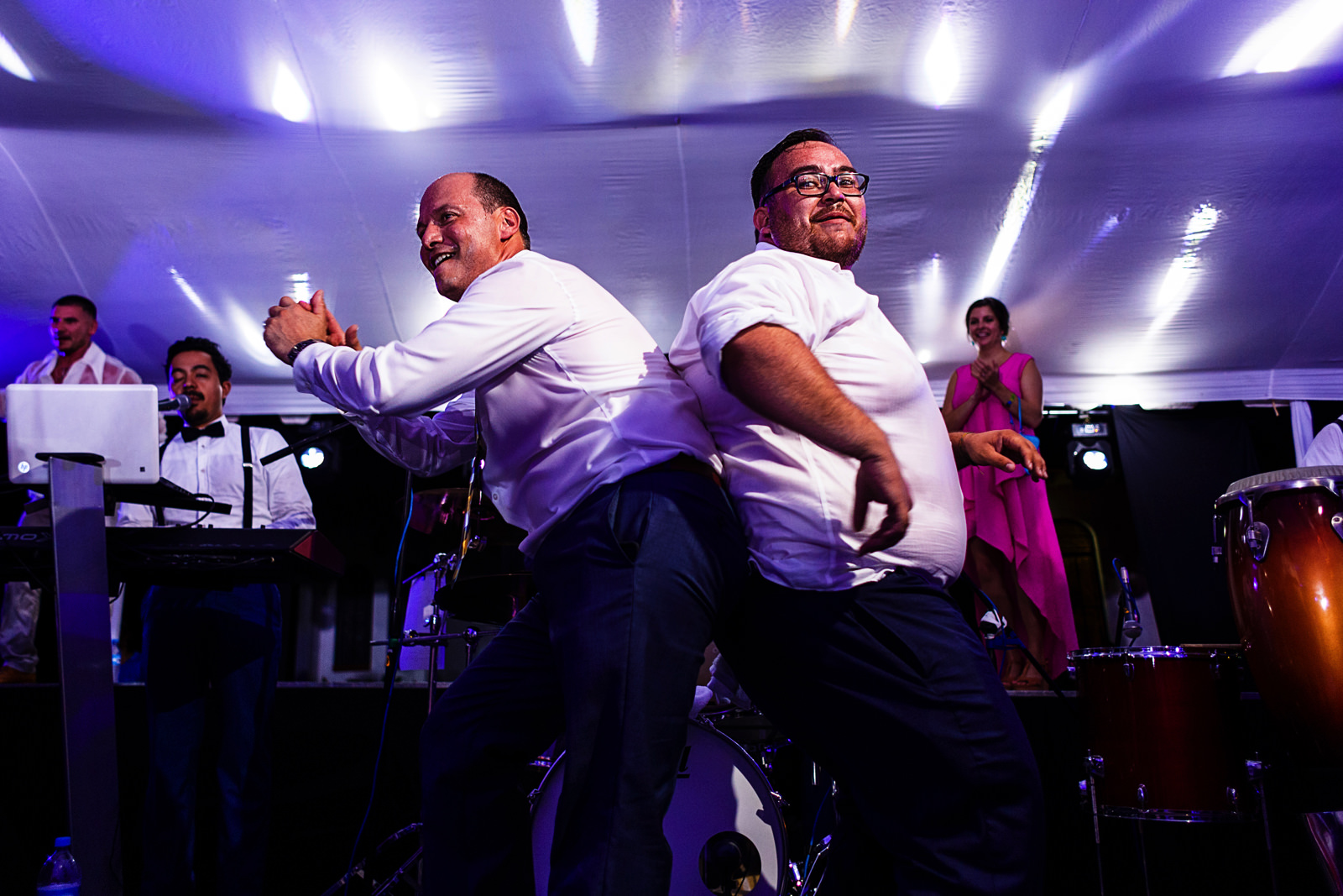 Dos hombres concursan bailando en el escenario junto a la banda musical