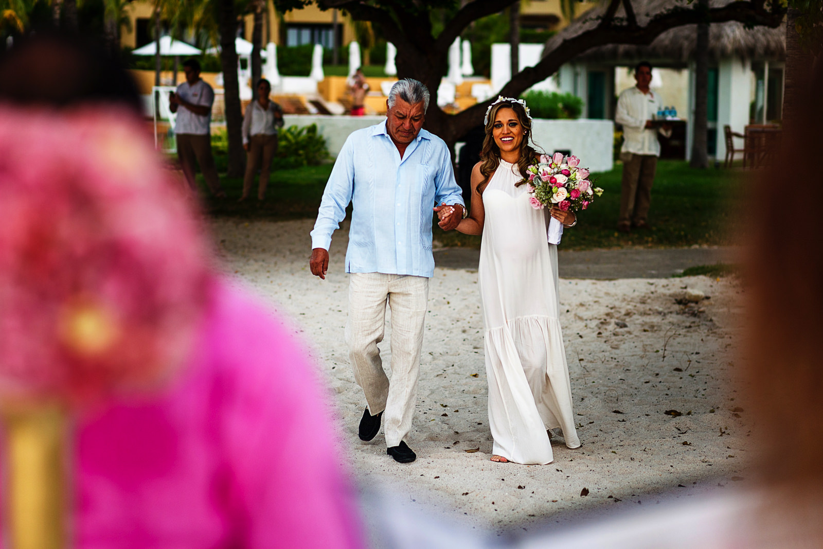 Papá y novia caminando hacia el altar durante ceremonia de boda destino en la playa