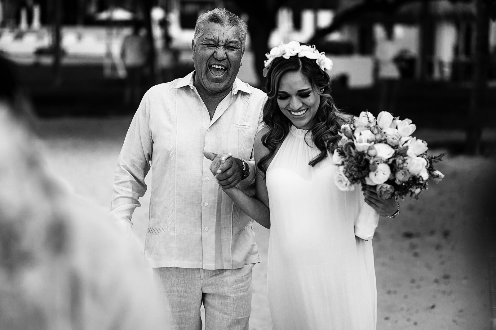 Papá de la novia carcajeando mientras camina hacia la boda