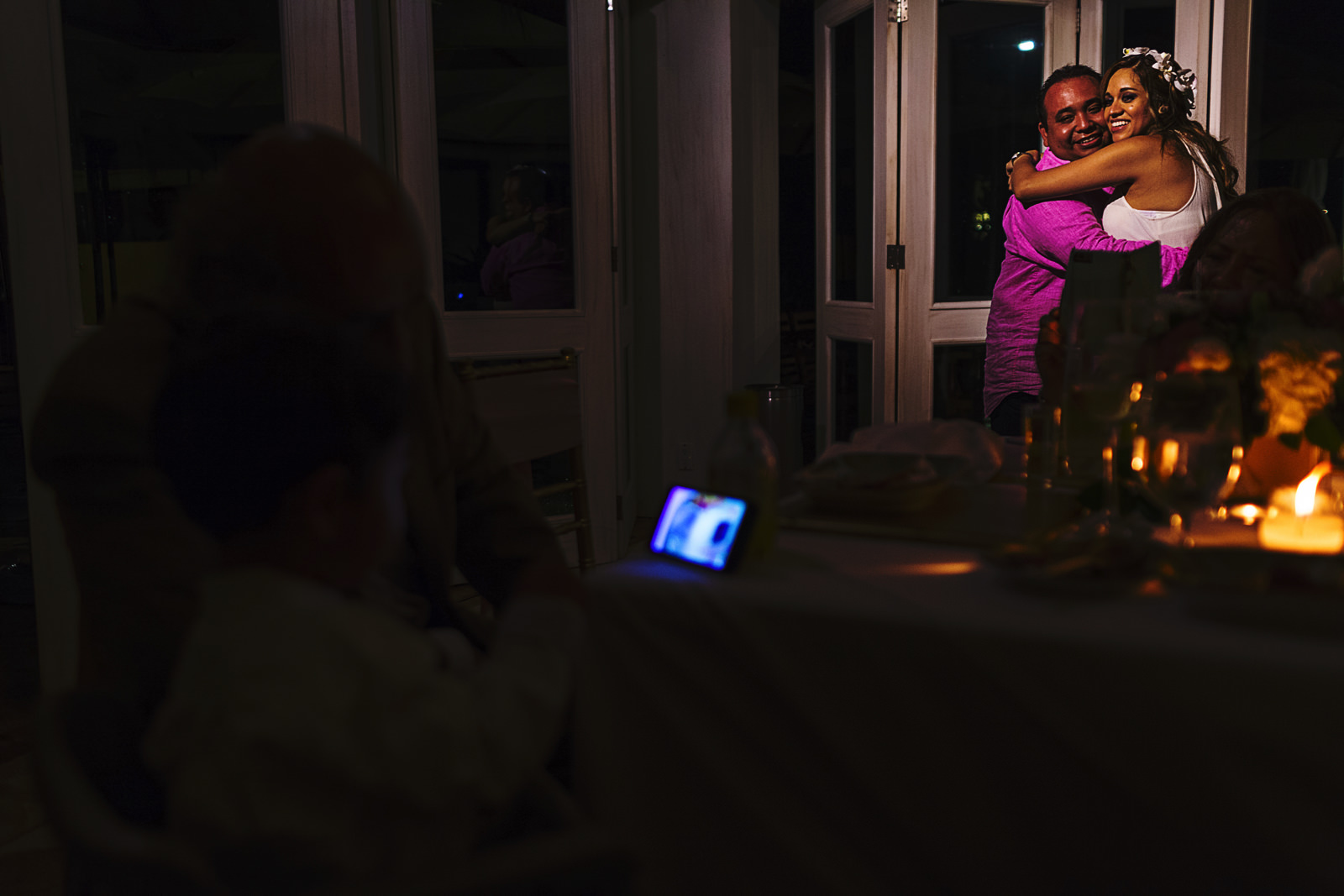 Pareja en su primer baile en la recepción de la boda mientras su hijo mira videos en un teléfono celular