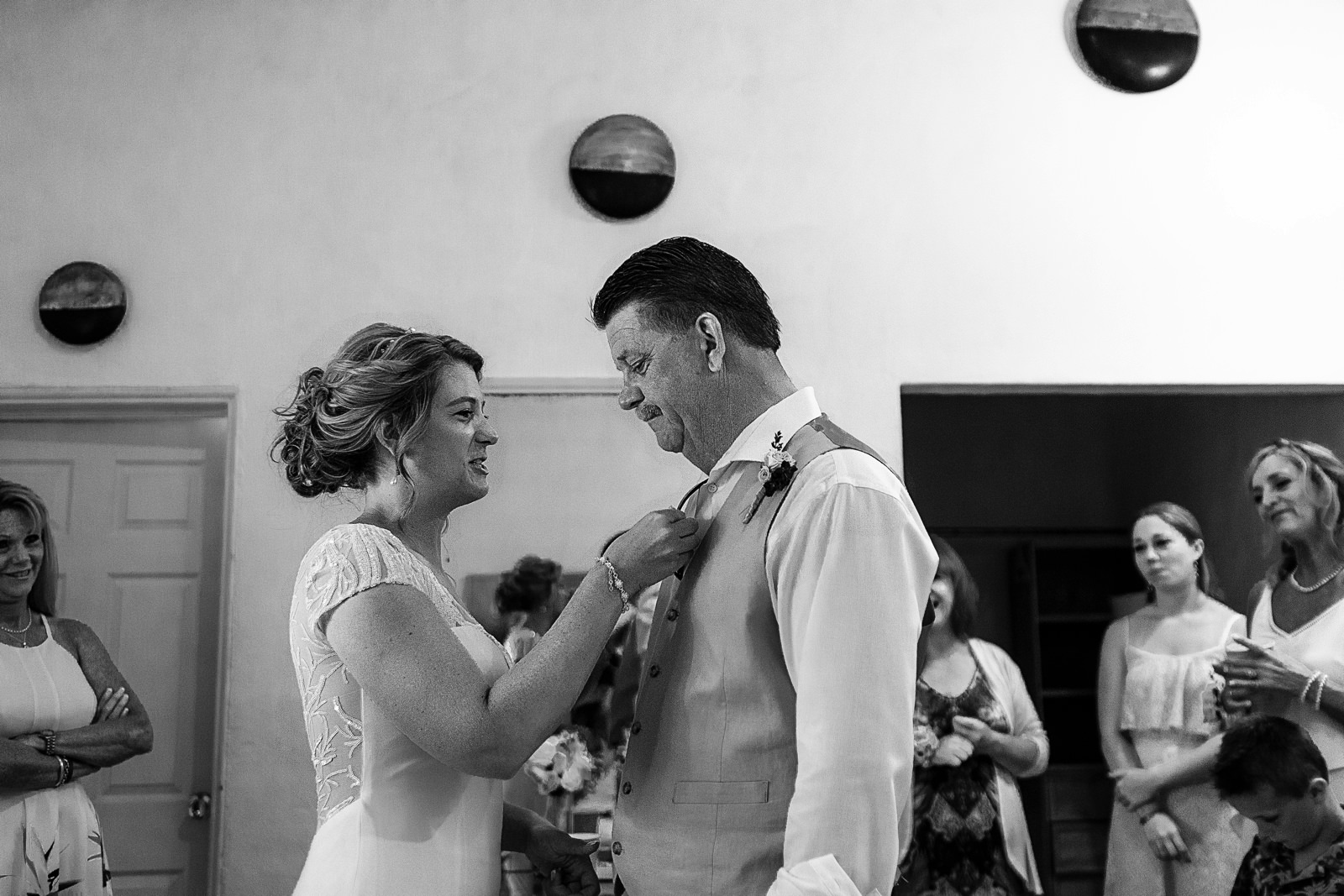 Bride fixing her father's suit and tie