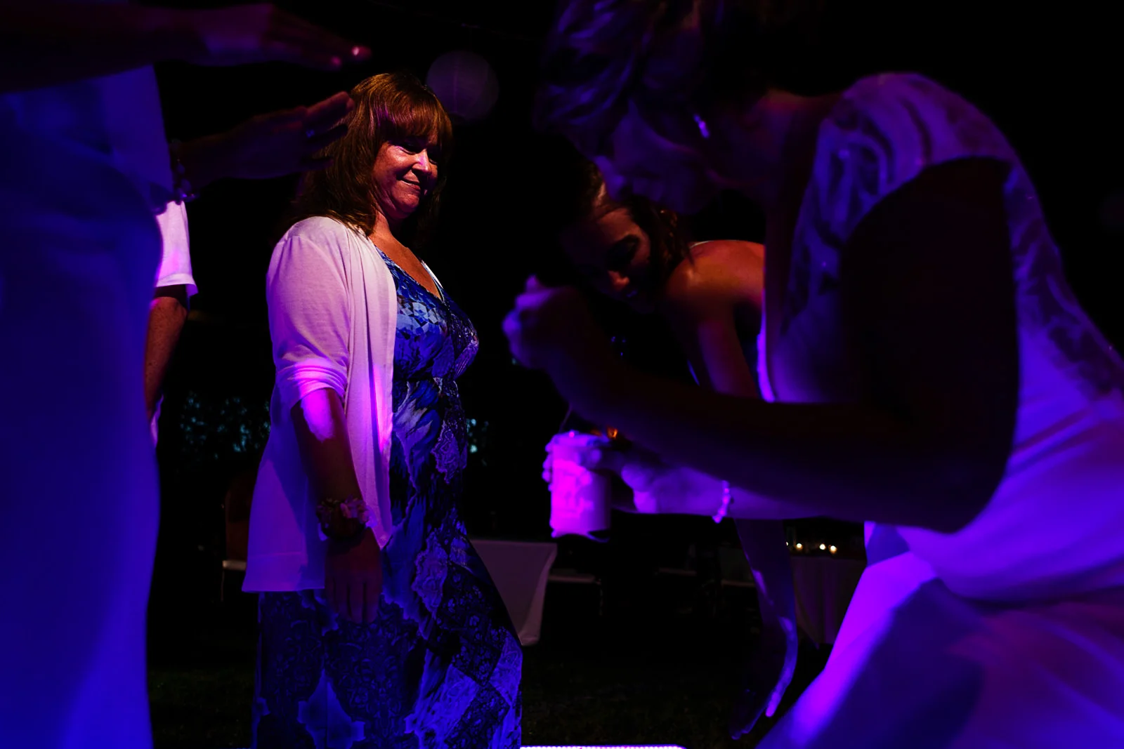 Mother of the groom watching how bride and sister dance together