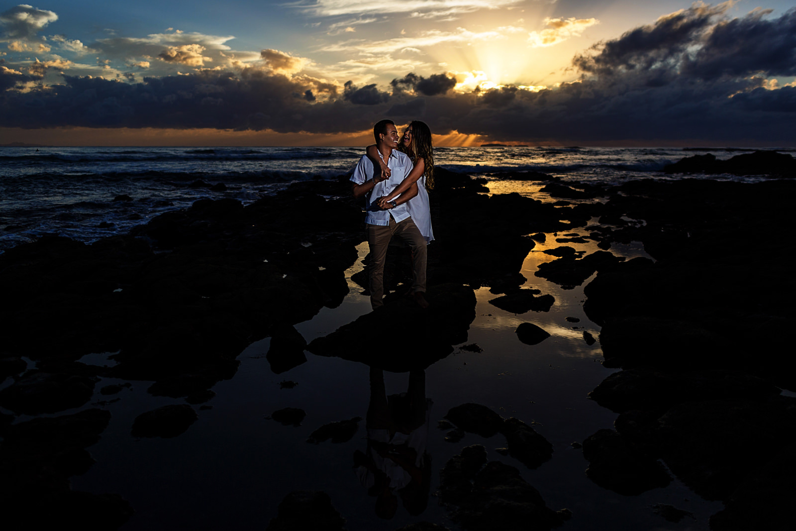 Prometida abrazando por detrás a su pareja al atardecer en una playa cercana a Puerto Vallarta