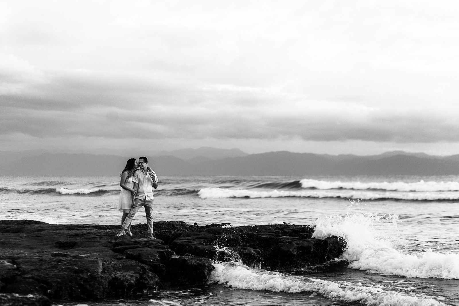Sesion casual en playa La Lancha cerca de Punta Mita, Vallarta. Las olas rompen en la roca que la pareja esta parada
