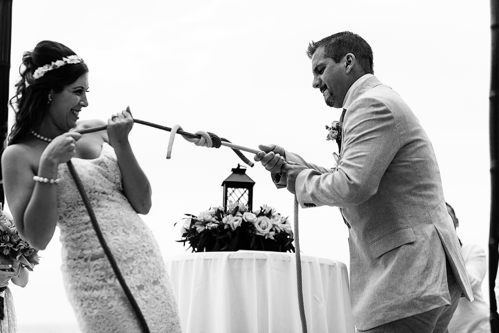 Groom and bride testing the strength of the knot they made as part of the wedding ceremony