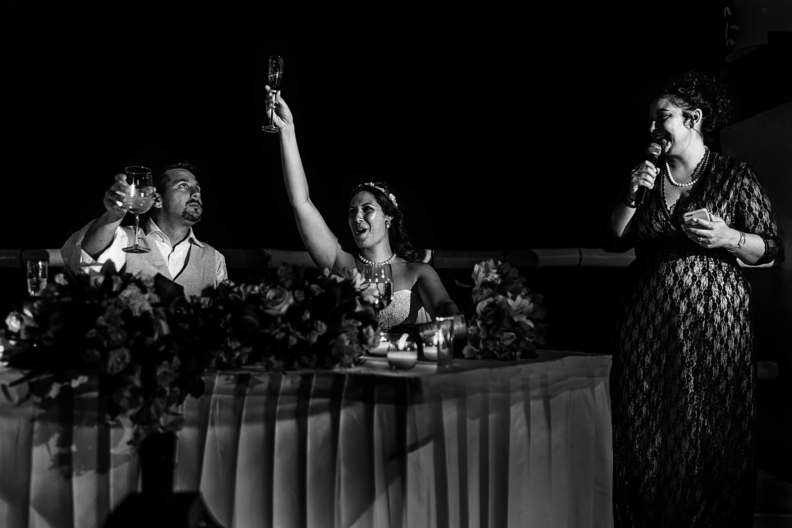 Maid of honor giving a speech, groom and bride raising their champagne glasses