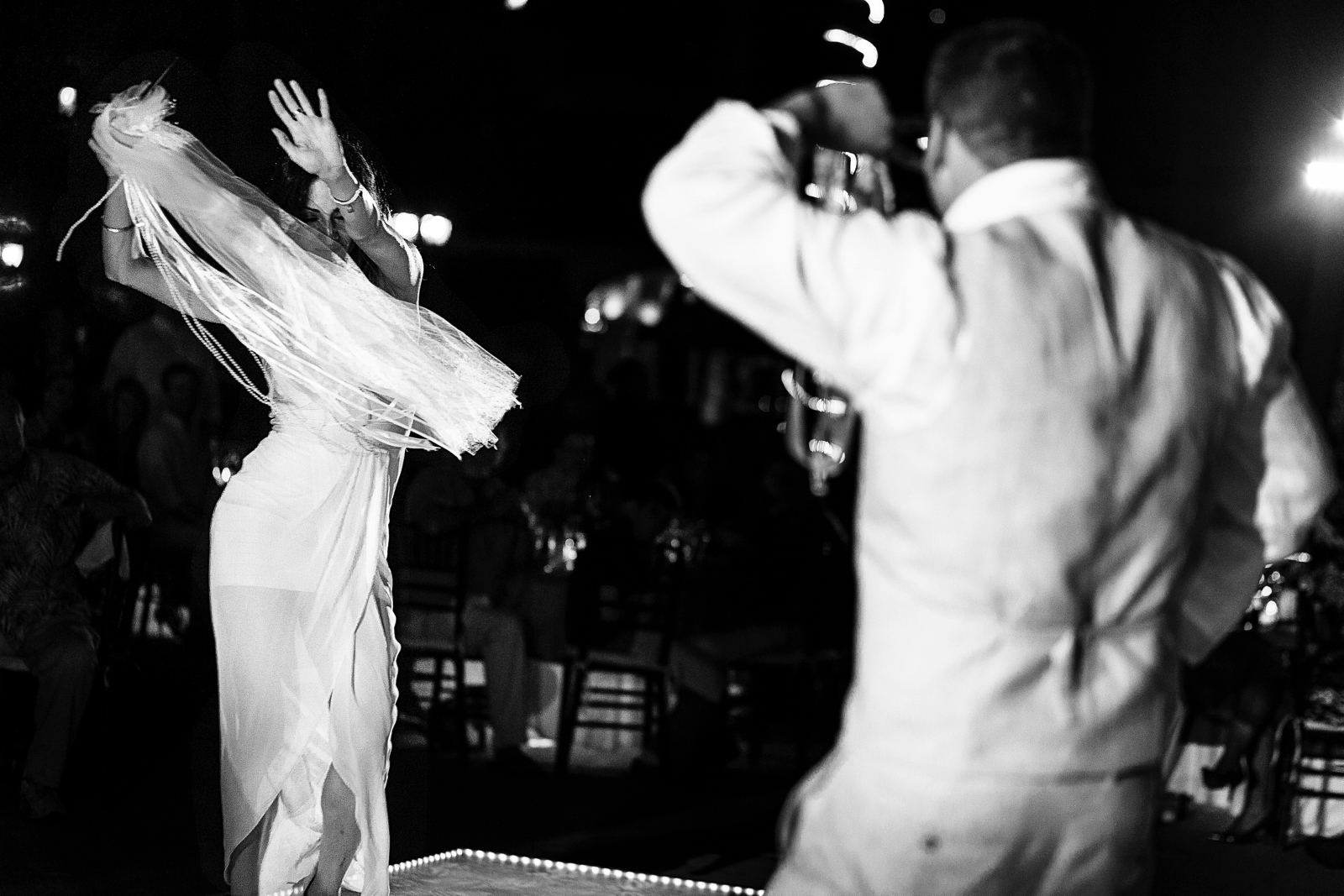 Wedding female guest dancing during traditional Persian dance for the groom to recover the wedding cake knife