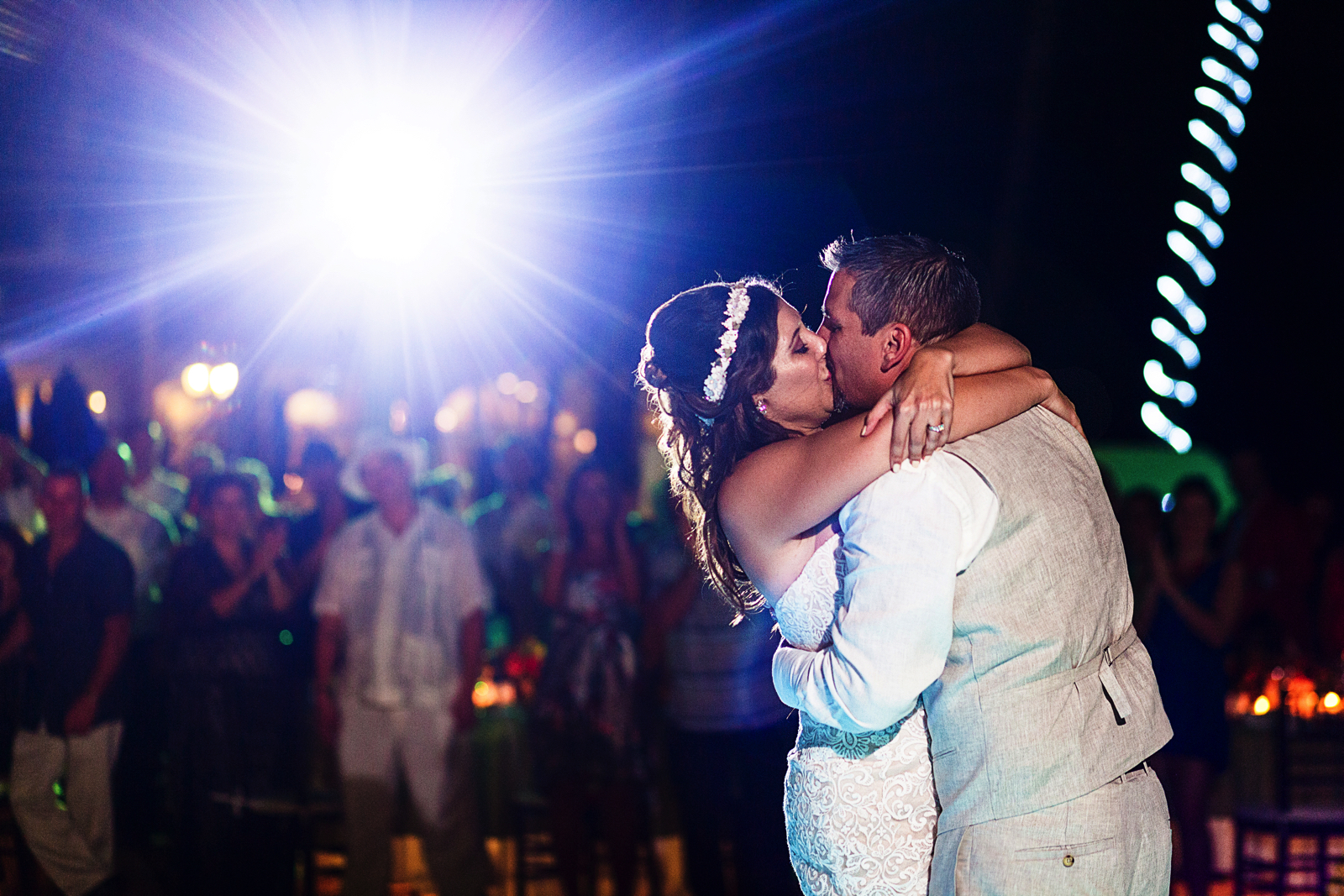 Groom and bride kissing on the dance floor during their entrance to the wedding reception