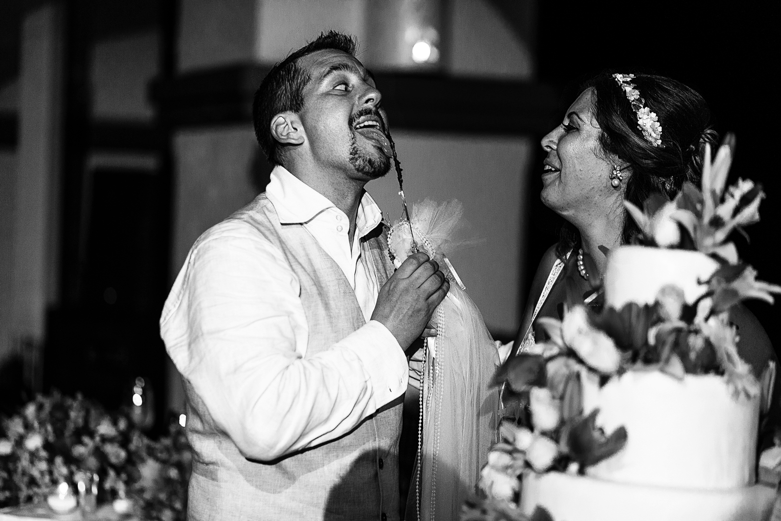 Groom licking the knife after cutting the wedding cake