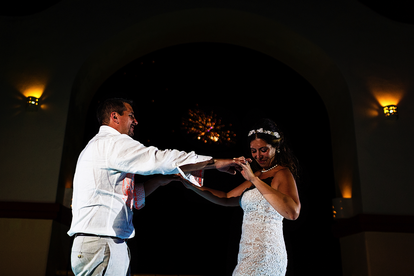 Fireworks in the background while groom and bride dance