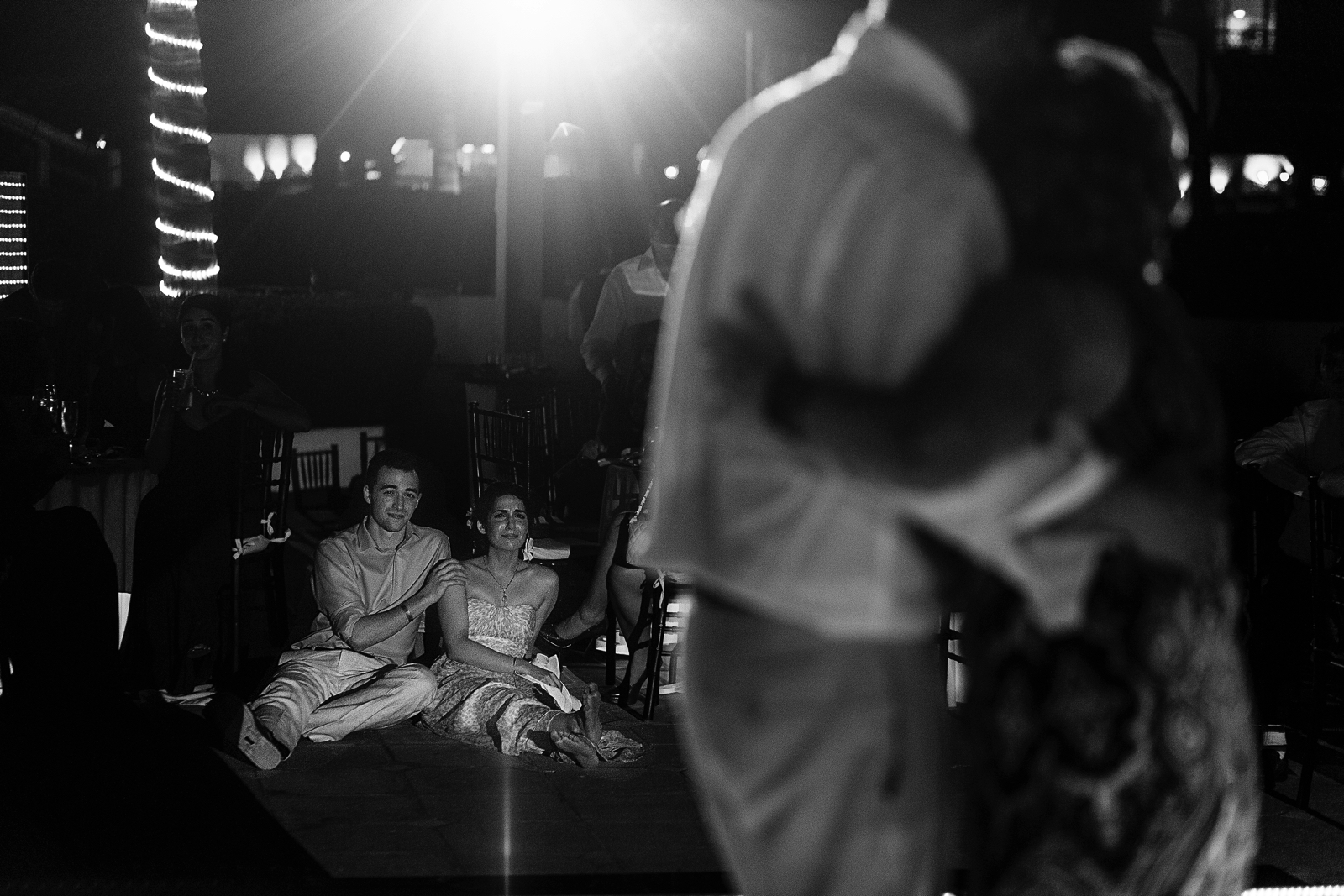 Sister of the bride crying while groom is dancing with his mother