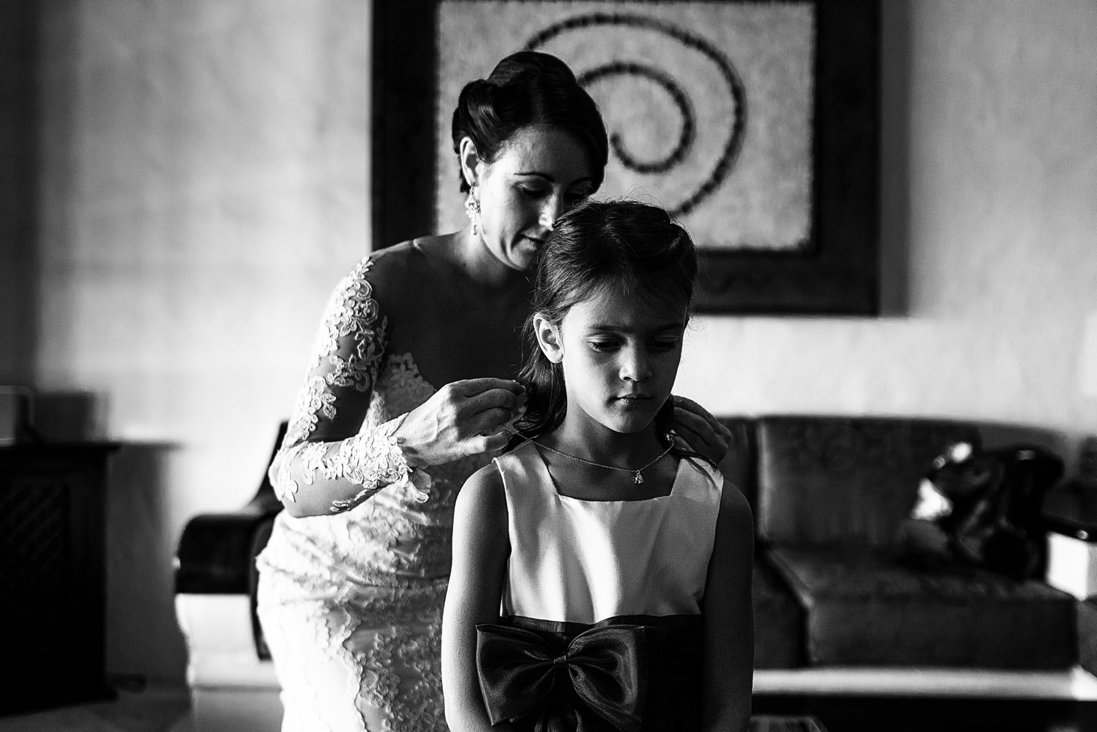Bride putting a necklace into a little girl