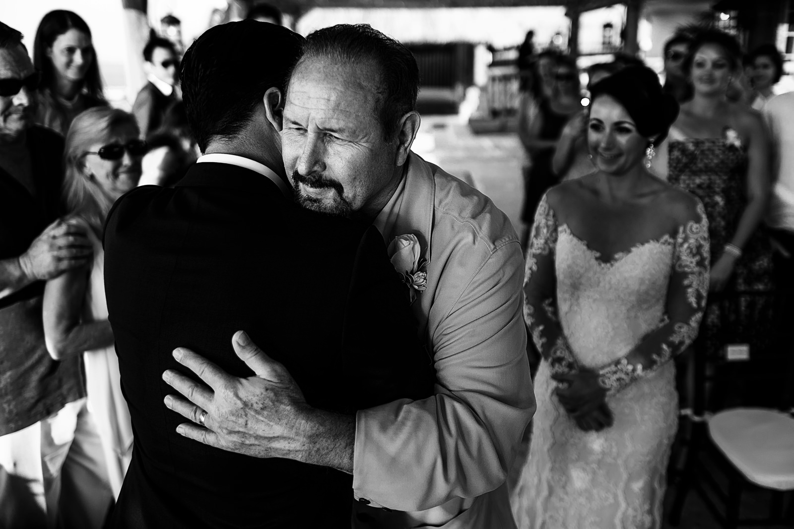 Father of the bride hugging the groom at the altar
