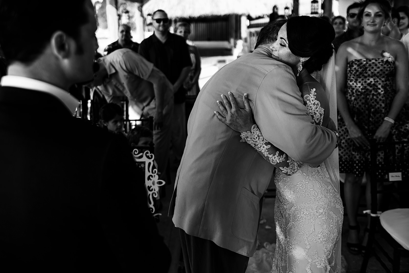 Father of the bride hugging the bride at the altar
