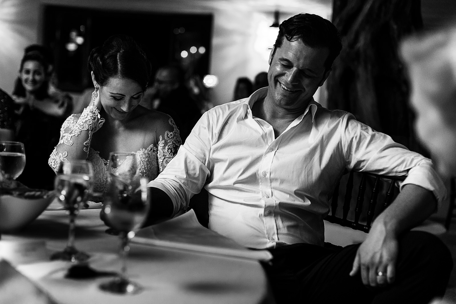 Groom and bride laughing during the speeches at their wedding dinner