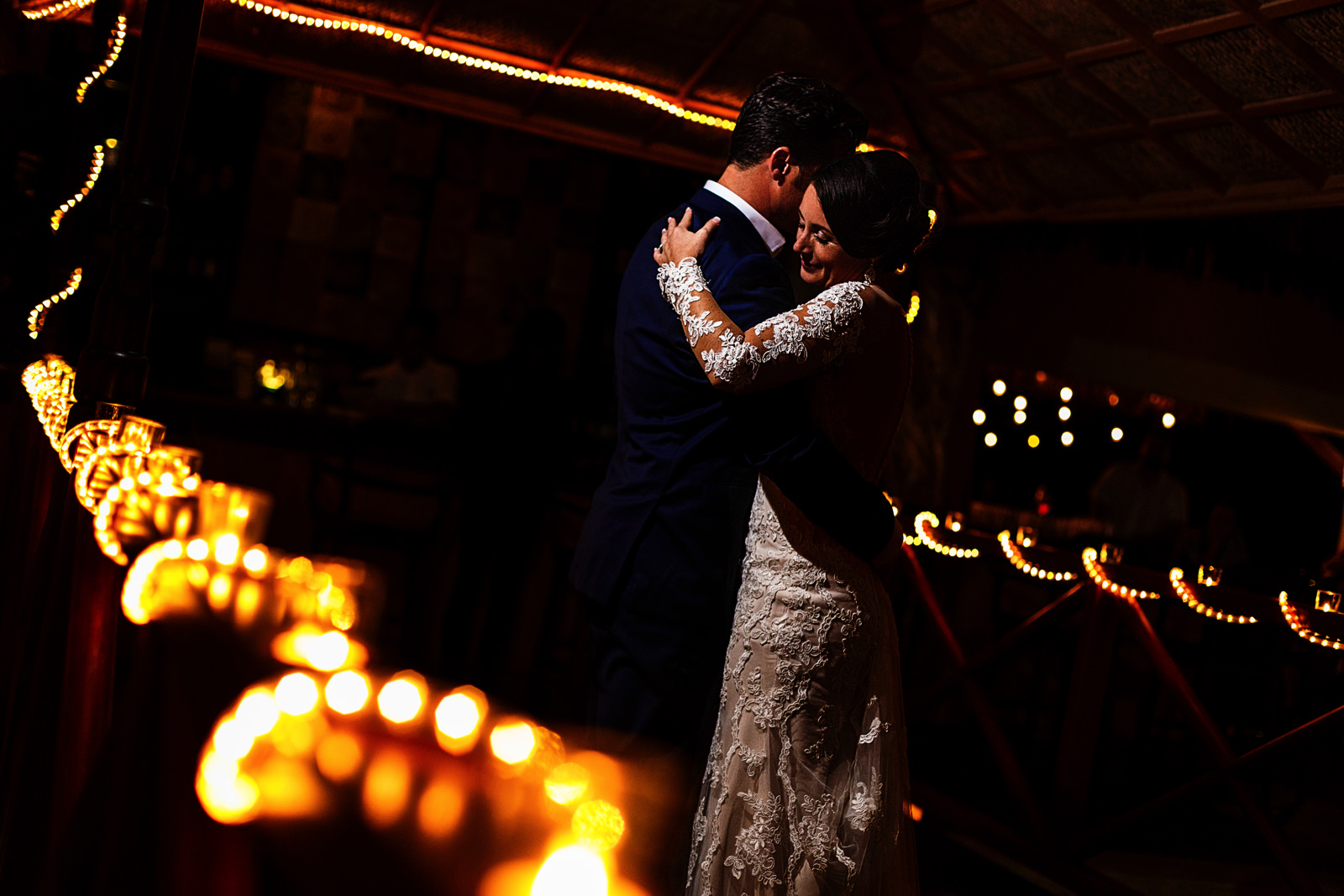 Groom and bride during their first dance on the beautifully lit  Playa Fiesta's bridge