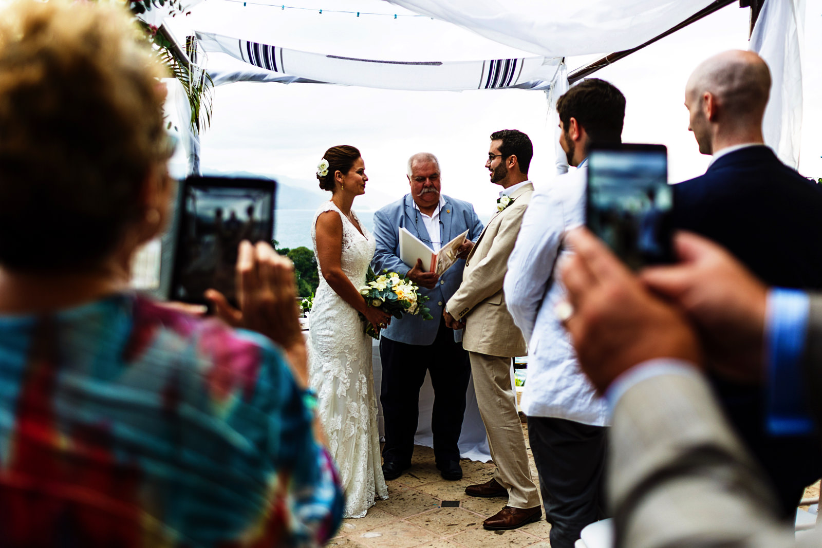 The guest taking pictures with their smartphones at the wedding ceremony