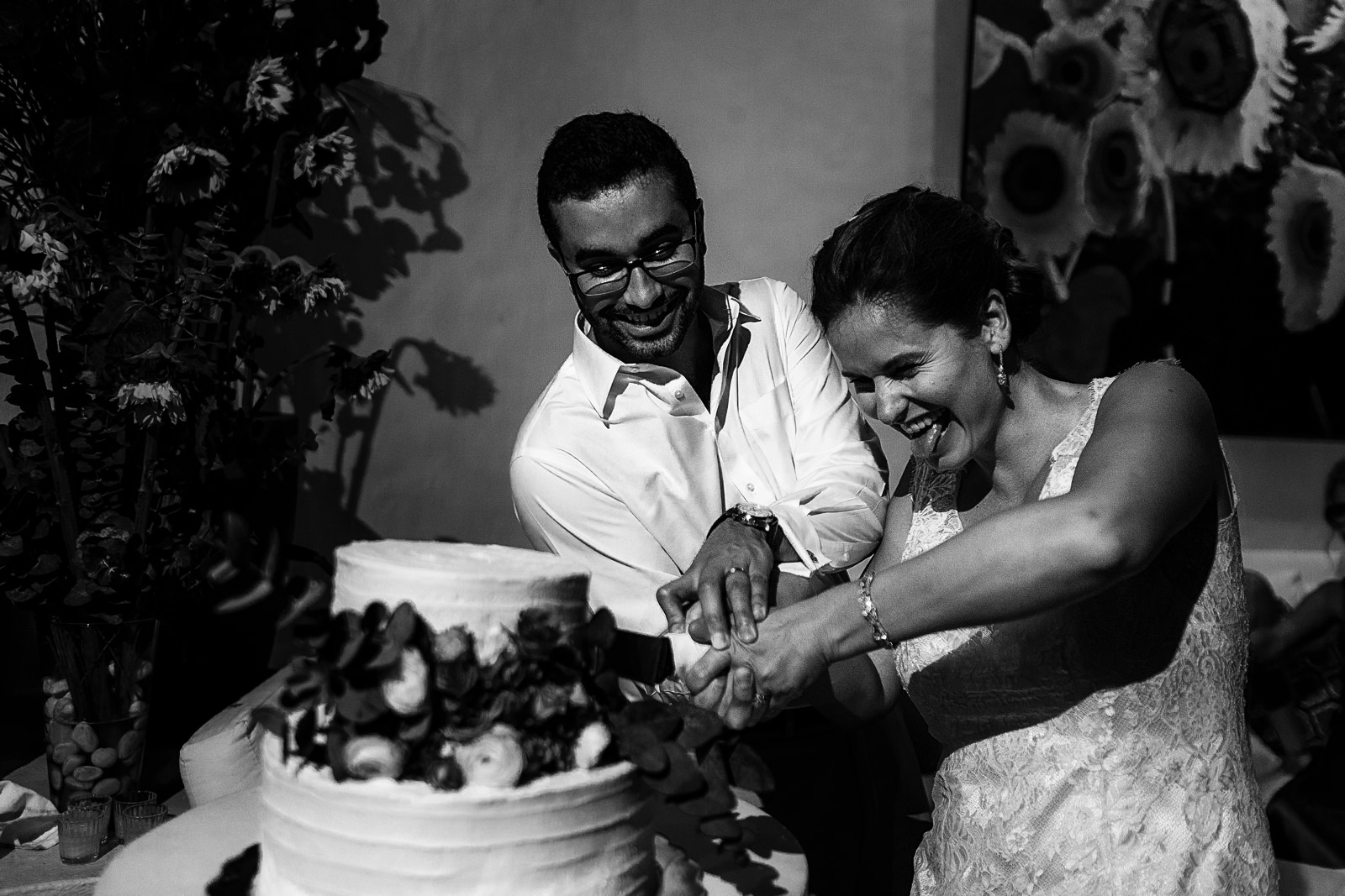 Bride sticking out her tongue as the couple is cutting the cake