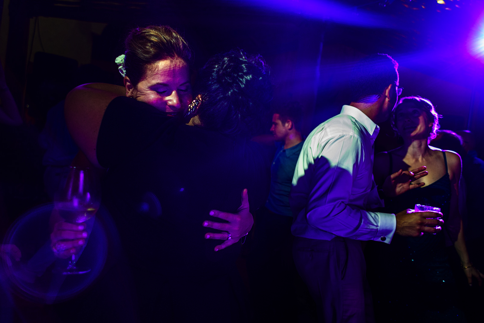 Friend of the bride giving her a hug in the middle of the dance floor