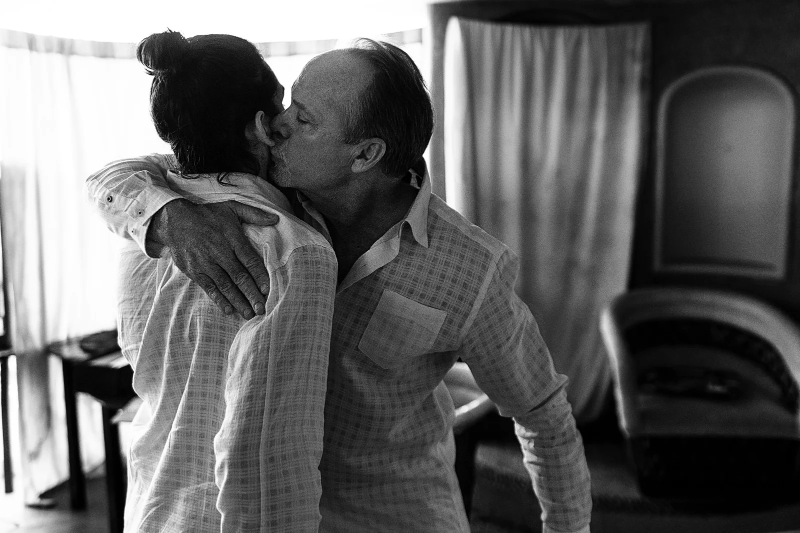 Father of the bride hugs and kiss his younger son